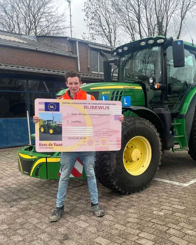 Geslaagde cursist in oranje vest met rijbewijsbord voor een groene lestrekker