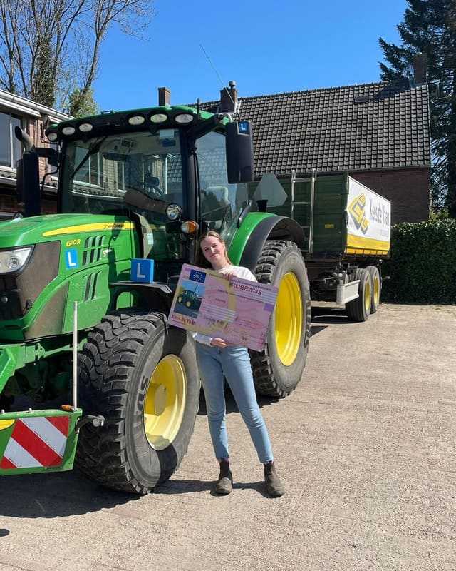 Geslaagde cursist met rijbewijsbord voor een groene lestrekker in de zon