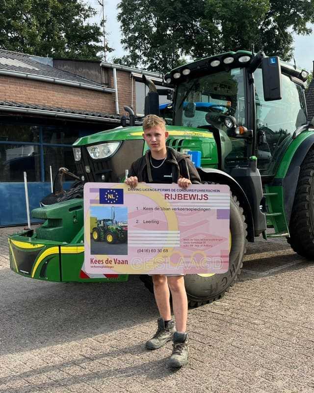 Geslaagd voor het trekkerrijbewijs: cursist houdt een groot rijbewijsbord vast voor de groene lestrekker